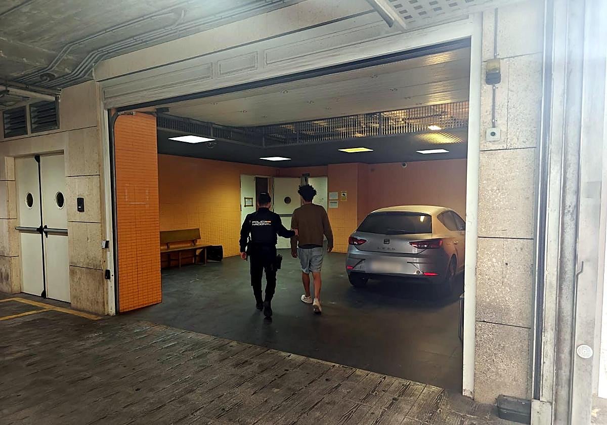 Un agente de la Policía Nacional custodia al detenido de camino de los calabozos.