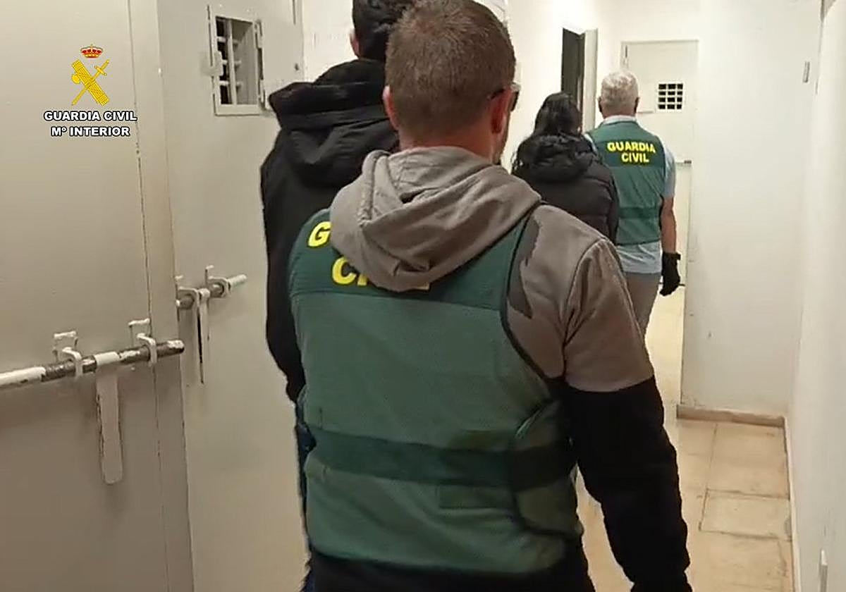 Los agentes llevan a la pareja de detenidos hasta los calabozos.